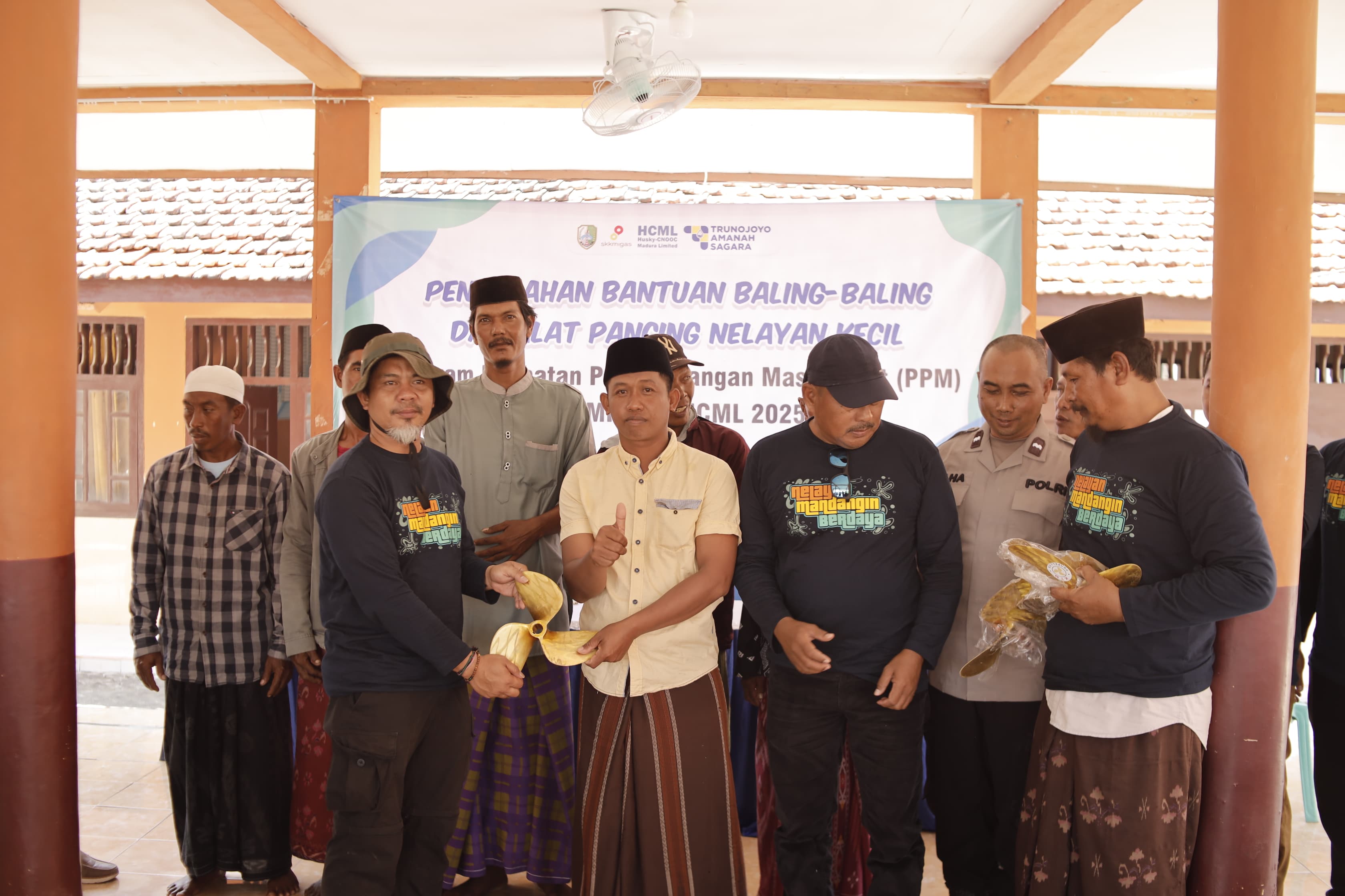 SIMBOLIS: Perwakilan HCML menyerahkan bantuan baling-baling kepada perwakilan nelayan di Balai Desa Pulau Mandangin, Sampang pada Selasa (2/12/2025)