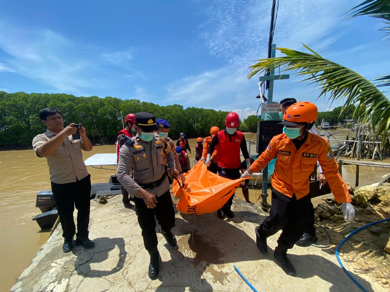 MENGENASKAN: Petugas saat mengevakuasi mayat di Dermaga Polairud Sampang, Rabu (10/12).
