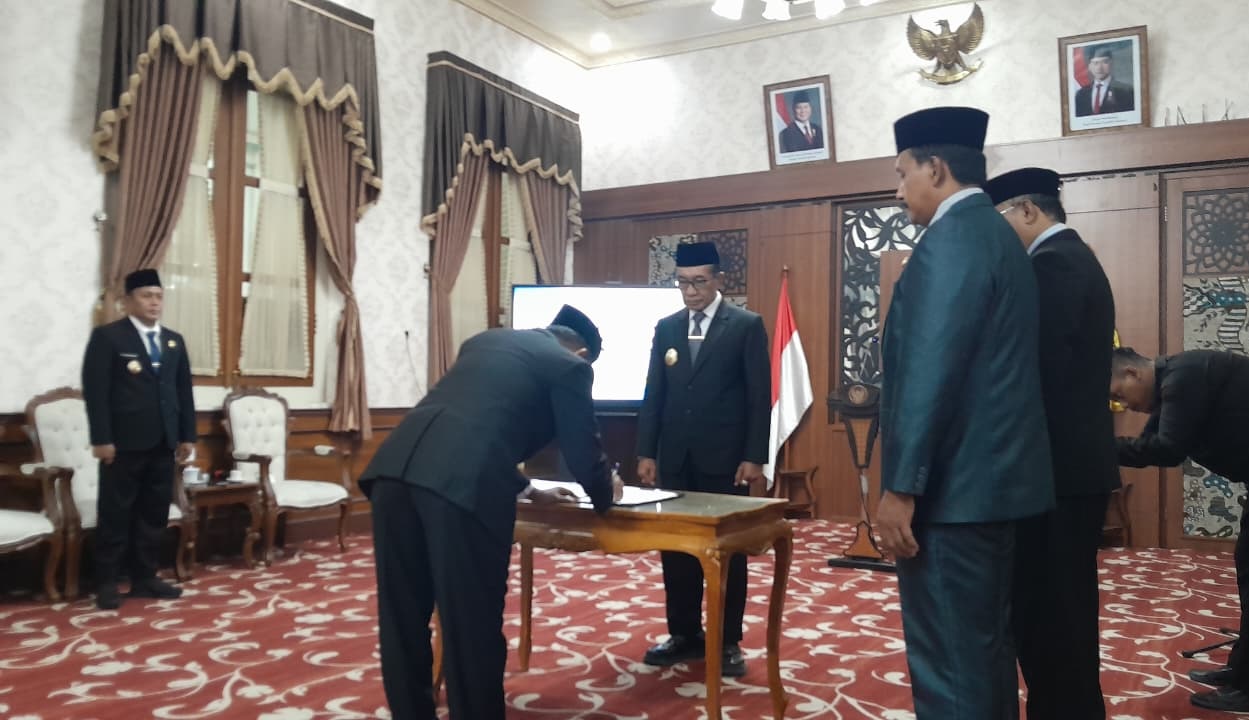 KOMITMEN: Pj Sekkab Pamekasan Taufikurrachman menandatangani berita acara pengambilan sumpah dan janji jabatan di hadapan Bupati Pamekasan  di Peringgitan Dalam Pendopo Ronggosukowati, Kamis (11/12).