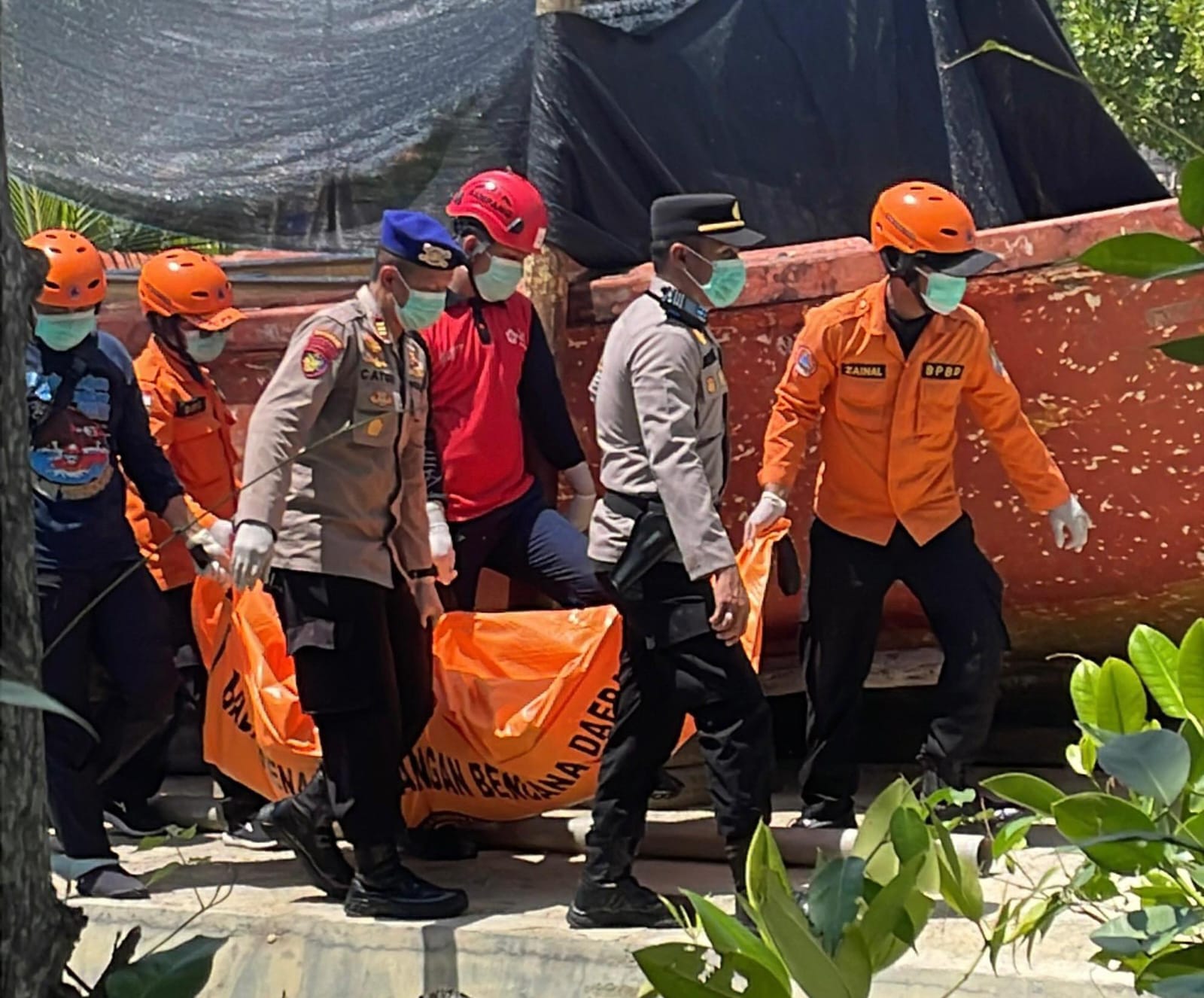 BELUM TERUNGKAP: Petugas mengevakuasi mayat di perairan Pulau Mandangin, Rabu (10/12).