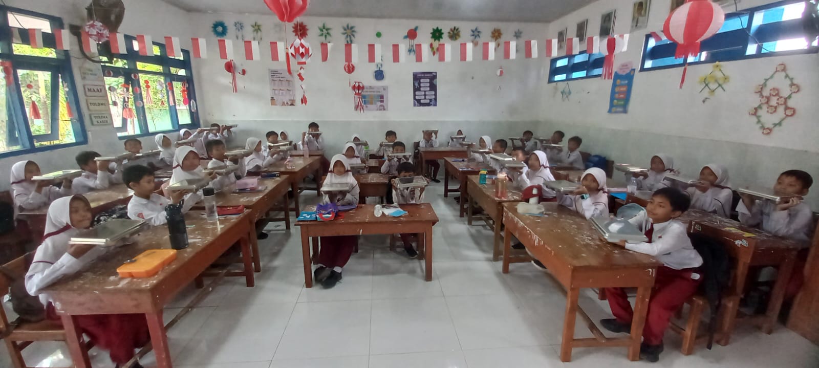 ANTUSIAS: Sejumlah siswa kelas IV SDN Gunung Sekar 2, Sampang sedang makan bersama di dalam kelas.