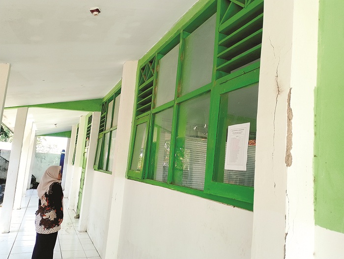 RETAK: Seorang guru berada di depan ruang kelas SMPN 1 Pangarengan, Sampang, yang direhab menggunakan DAK 2024, Jumat (12/12). (UBAIDILLAHIR RAIE/JPRM)