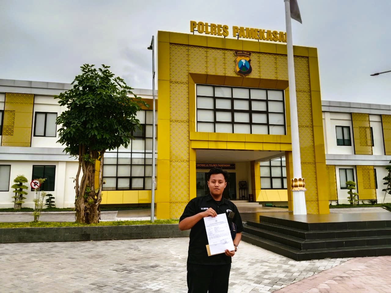 JADI ATENSI: Ibrahim, warga Desa Tamberu Timur, Kecamatan Sokobanah, Sampang, menunjukkan bukti laporan dan dus ponselnya saat berada di Mapolres Pamekasan, Senin (15/12).