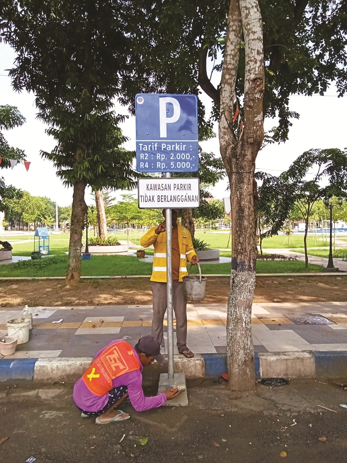 TINGKATKAN PAD: Petugas Dishub Sampang memasang rambu parkir non-berlangganan di Jalan Wijaya Kusuma, Kamis (20/3).(DISHUB SAMPANG UNTUK JPRM)