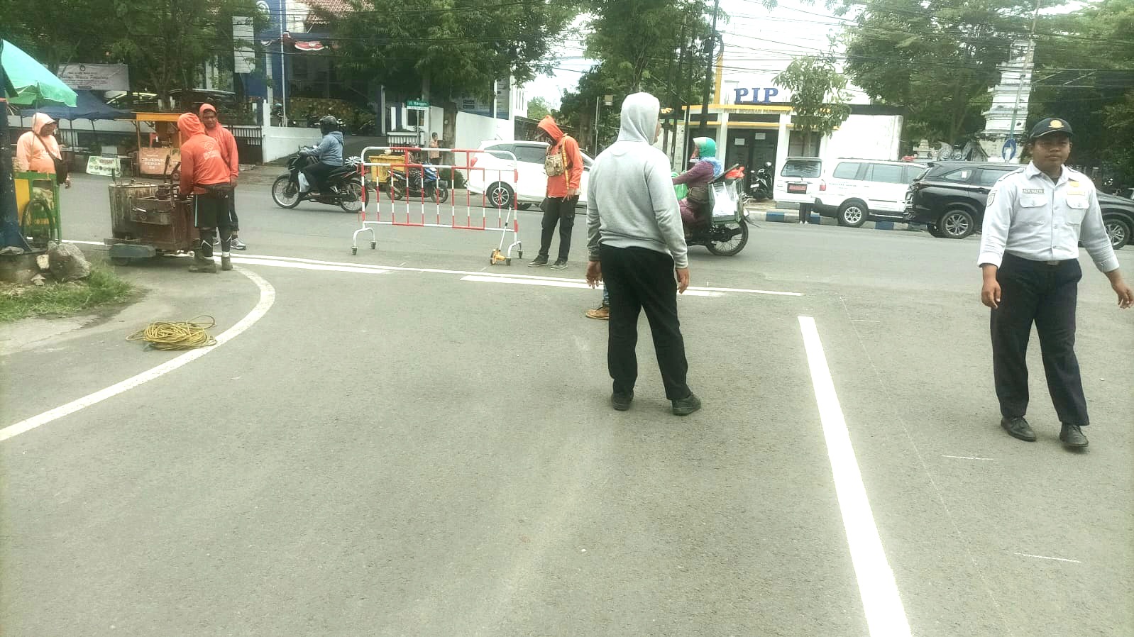 DIAWASI: Petugas Dishub Sampang memantau pekerjaan pengecatan ulang markah ruas Jalan KH Wachid Hasyim, Sampang, Selasa (11/11).(DISHUB SAMPANG UNTUK JPRM)