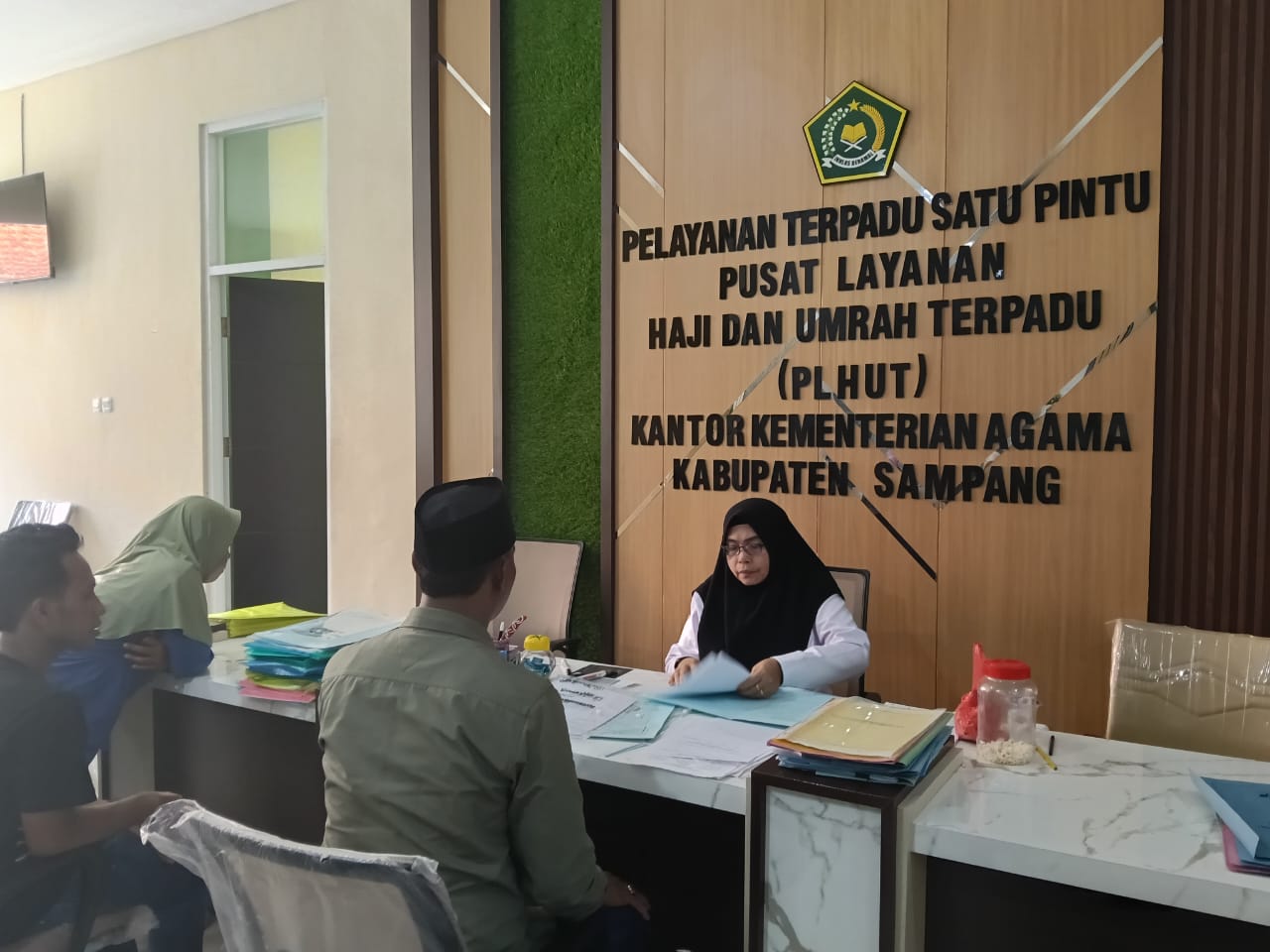 ADMINISTRASI: Petugas saat melayani CJH dalam pengumpulan berkas pelunasan di kantor Kemenag Sampang, Senin (16/12).