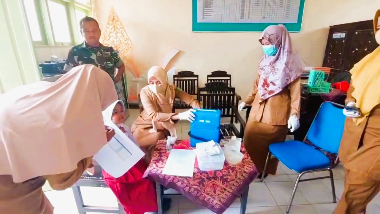 PENCEGAHAN: Petugas kesehatan melakukan imunisasi di SDN Babbalan, Kecamatan Batuan, Sumenep, Selasa (26/8).