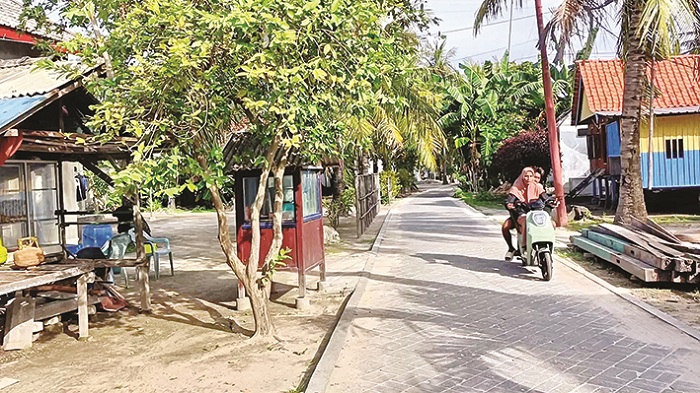 TENAGA LISTRIK: Warga mengendarai sepeda listrik di Jalan 2, Desa/Pulau Pagerungan Besar, Kecamatan Sapeken, Sumenep, Selasa (9/12). (LUKMAN HAKIM AG./JPRM)