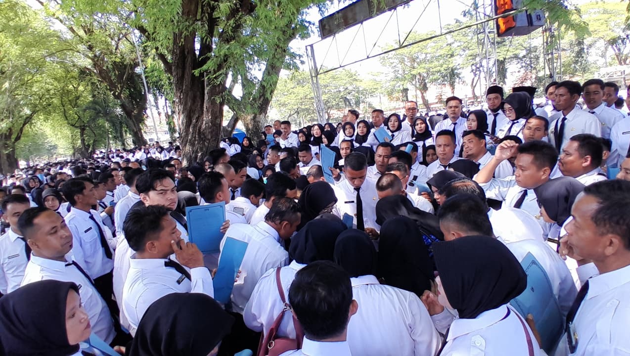 BERDESAKAN: ASN PPPK paro waktu di lingkungan Pemkab Pamekasan antre mengambil SK pengangkatan di Lapangan Nagara Bhakti, Rabu (17/12).