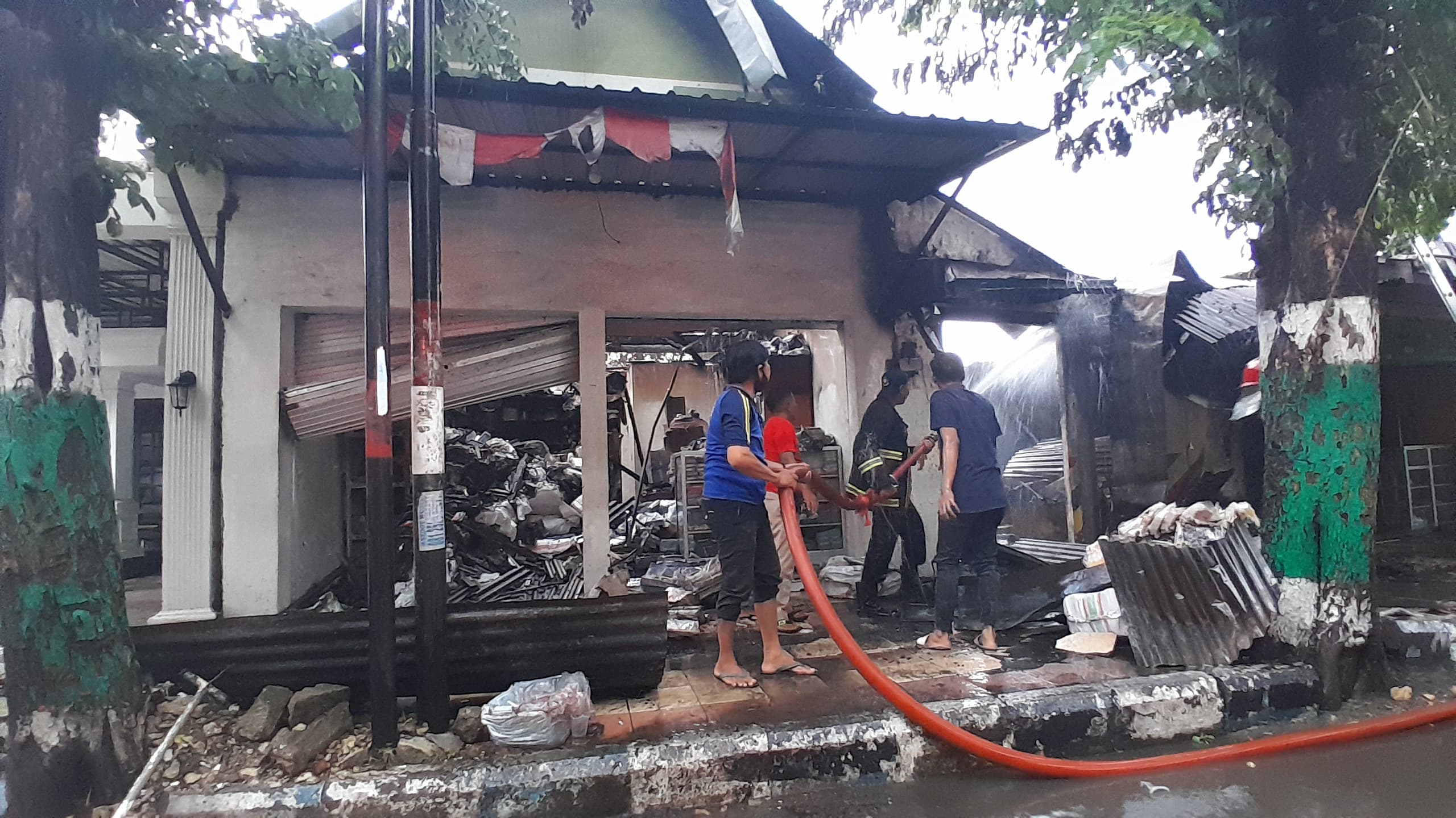 HANGUS: TIM Damkar Pamekasan saat melakukan pemadaman dalam peristiwa kebakaran di Jalan Trunojoyo, Sabtu (20/12).
