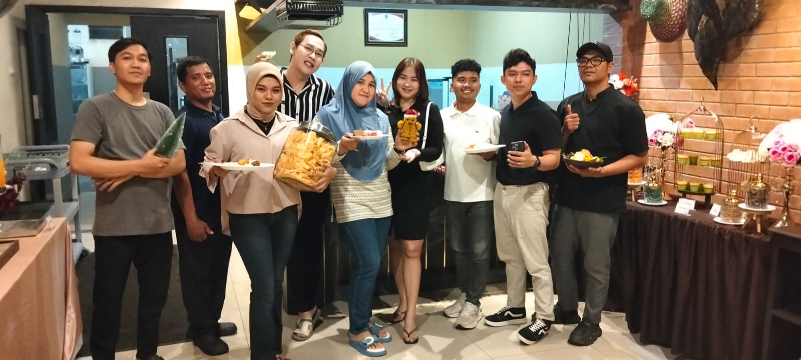 BERI LAYANAN TERBAIK: Manajer Sales dan Marketing de Baghraf Hotel Sumenep Putri Anggraeni (tengah), berfoto bersama staf di lantai 5A restoran pada Sabtu (20/12) malam.