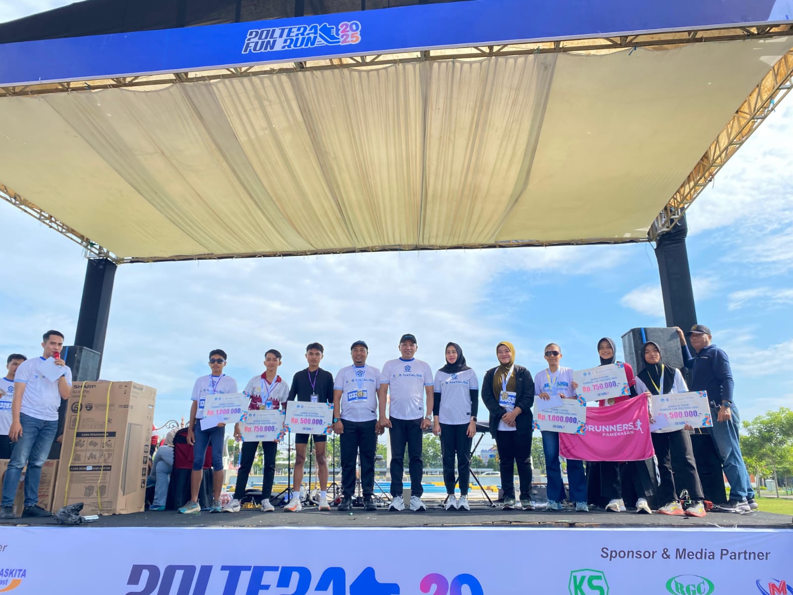 SUPPORT: Bupati Sampang  tengah) didampingi Ketua TP PKK Sampang dan Direktur Poltera (hijab cokelat) berfoto bersama dengan para juara Poltera Fun Run di Alun-Alun Trunojoyo, Minggu (21/12)