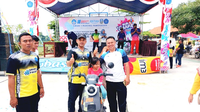 BERUNTUNG: Peserta menerima hadiah utama sepeda listrik pada Fun Walk SMAN 1 Pakong, Pamekasan, Minggu (21/12). (M. KHOLIL RAMLI/JPRM)