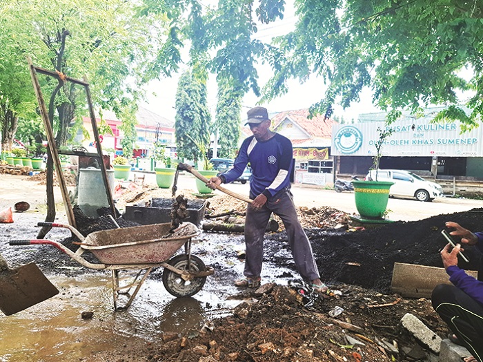 MOLOR: Pekerja tengah membersihkan material proyek di Taman Bunga Pottre Koneng Sumenep Senin (22/12). (MOH. LATIF/JPRM)