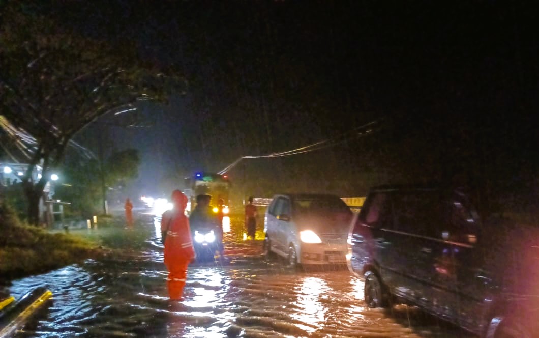 TERDAMPAK: Petugas sedang melakukan pemantauan di Jalan Raya Ambat, Pamekasan, Minggu (21/22).