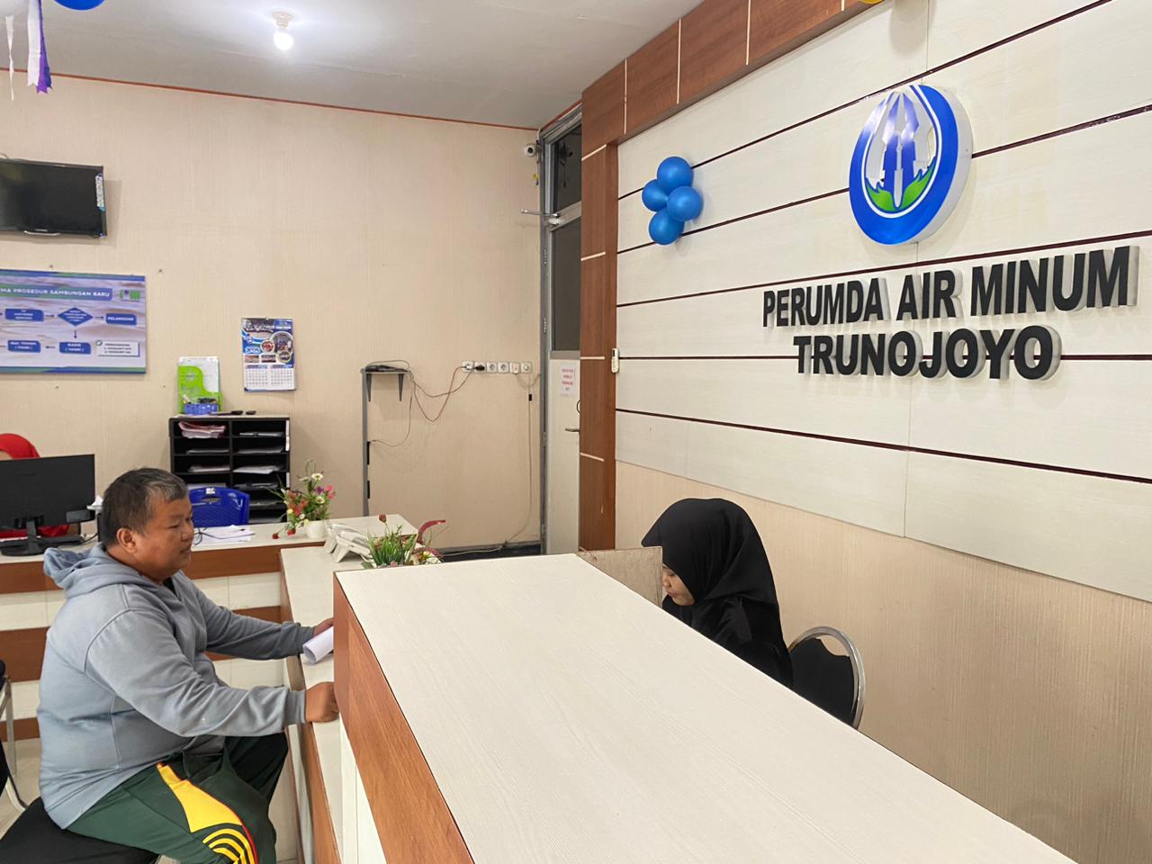 PENDAPATAN: Petugas saat melayani pelanggan di kantor Perumdam Trunojoyo Senin (22/12).