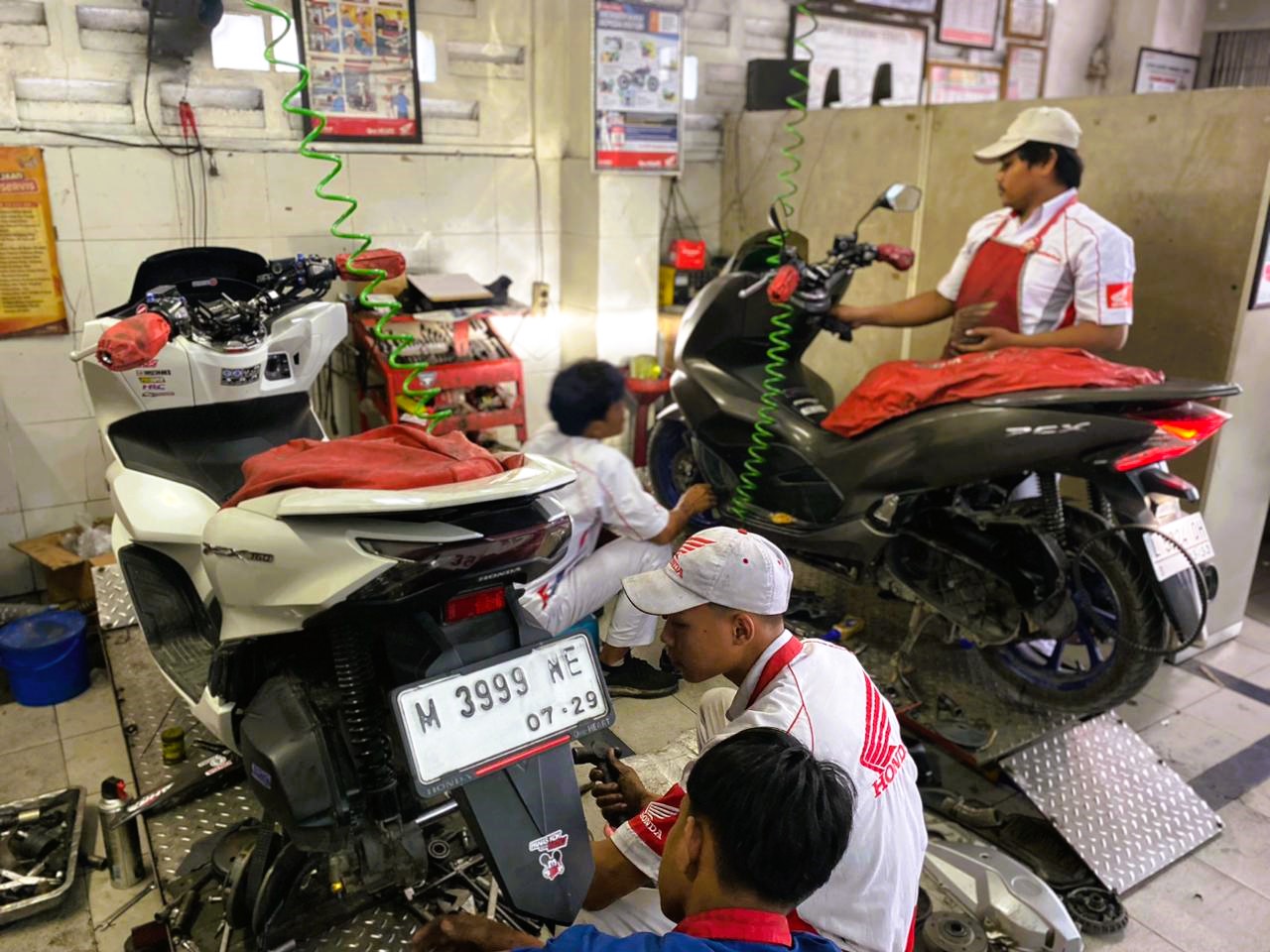 FOKUS: Pekerja sedang memperbaiki sepeda motor di dealer CV Al Amin Agung Motor, Sampang, Kamis (4/12).