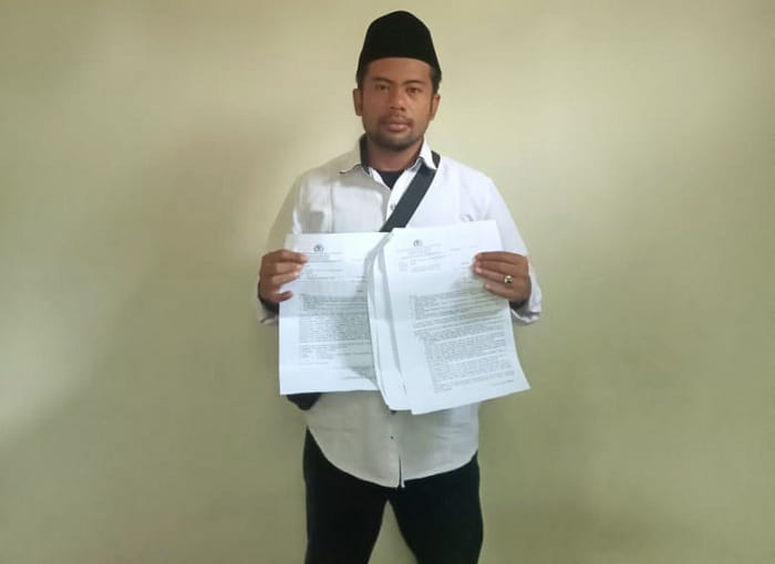 MEMINTA KEADILAN: Pelapor Suherman menunjukkan bukti pelaporan penganiayaan ke Polres Bangkalan, Minggu (12/10). (SUHERMAN UNTUK JPRM)