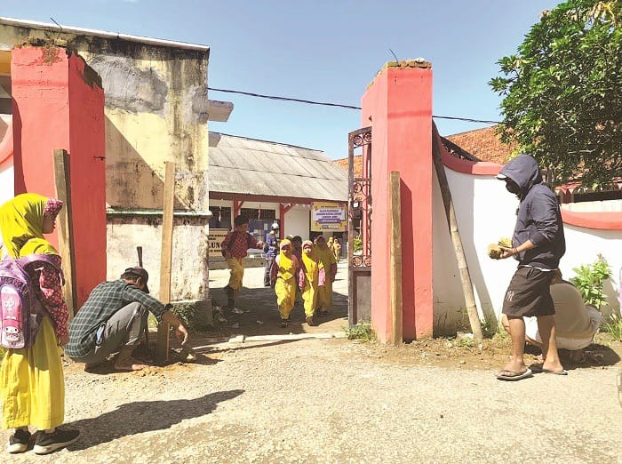 BERMASALAH: Sejumlah warga menyegel gerbang SDN Balung 1 Kecamatan Arosbaya, Bangkalan, Rabu (17/12). (H. MANSUR UNTUK JPRM)