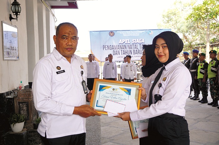 APRESIASI: Kepala Lapas Kelas II-A Pamekasan Syukron Hamdani beri penghargaan kepada petugas sipir Tarisa Vellsa Agustin saat apel, Rabu (24/12). (LAPAS KELAS II-A PAMEKASAN UNTUK JPRM)