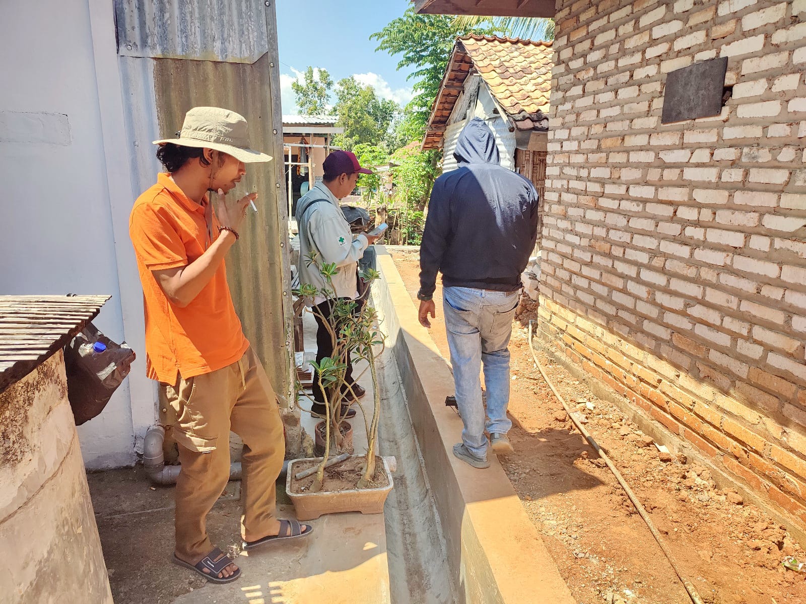 PERBAIKI LINGKUNGAN: Warga melihat pengerjaan drainase di Kecamatan Larangan.