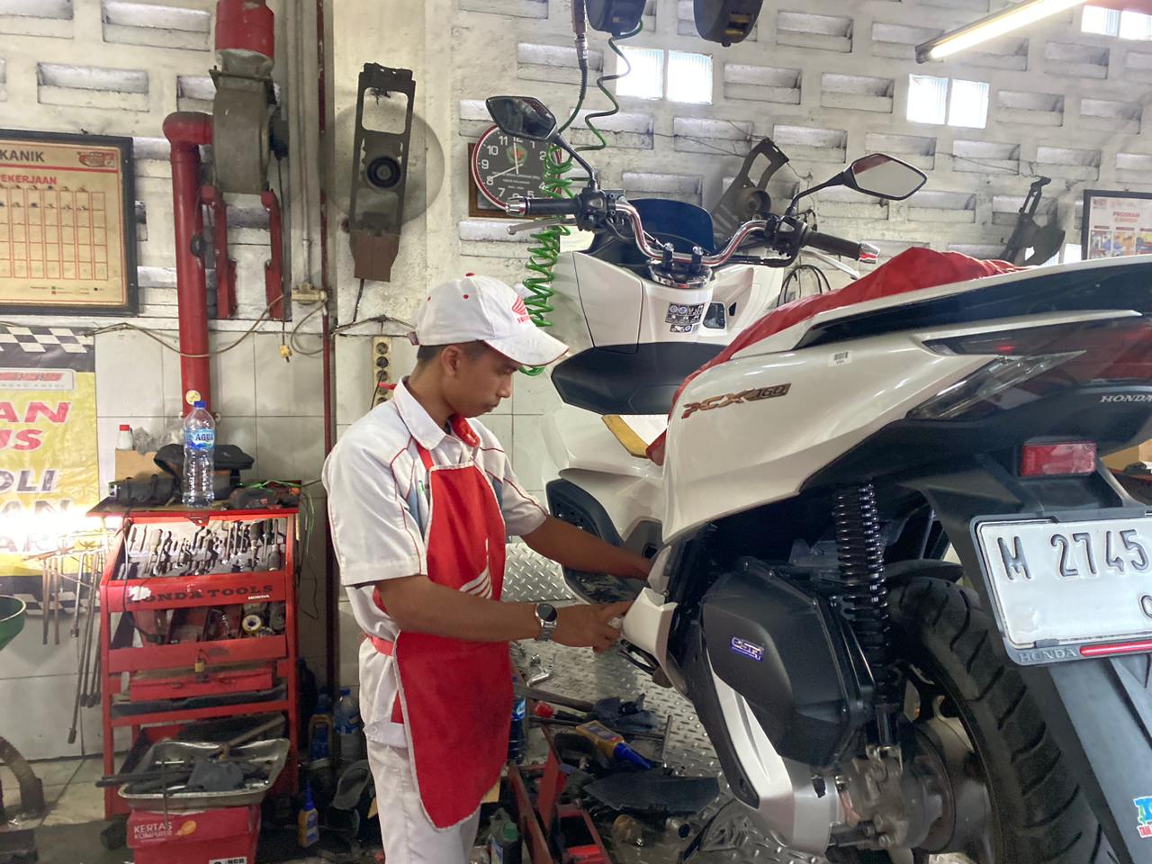 FOKUS: Pekerja sedang memperbaiki sepeda motor pelanggan diler di Jalan KH Wahid Hasyim, Sampang, Kamis (4/12).