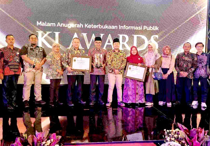 KOMITMEN: Bupati Pamekasan KH Kholilurrahman menerima penghargaan predikat Kabupaten Informatif pada ajang KI Awards Jatim 2025, Sabtu (29/11). (PROKOPIM UNTUK JPRM)