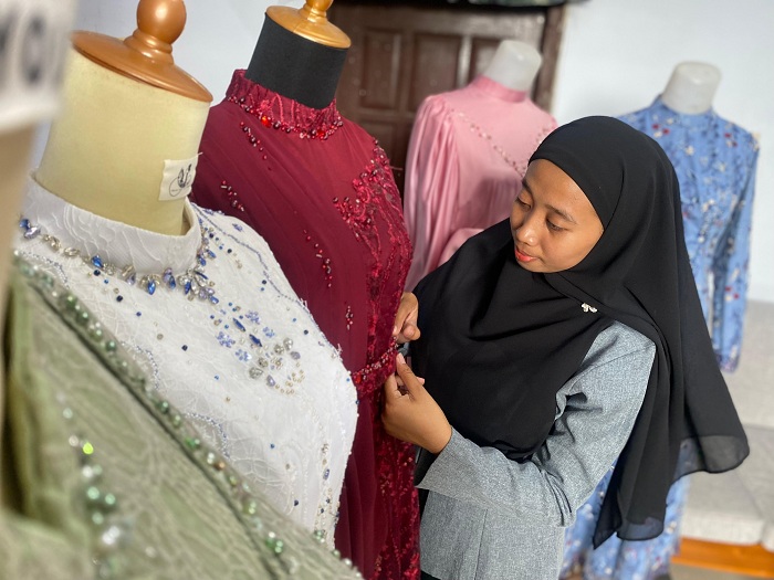 FOKUS: Salah seorang fashion designer saat memasang payet pada baju di Desa Kalangan Prao, Kecamatan Jrengik, Jumat (12/12). (AYU LATIFAH/JPRM)