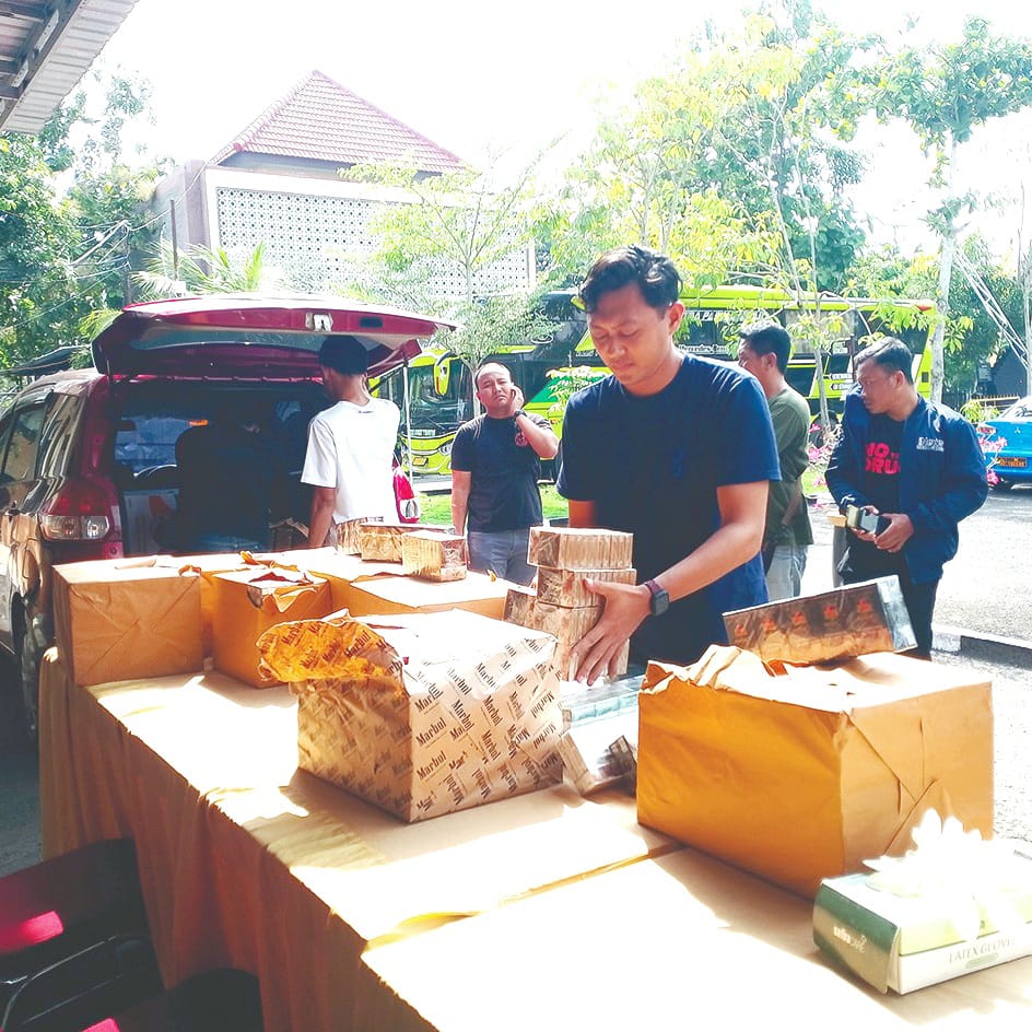 DIAMANKAN: Anggota Polres Sampang berada di sekitar BB rokok ilegal, Selasa (23/12). (UBAIDILLAHIR RAIE/JPRM)
