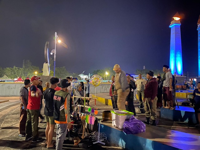 BERSITEGANG: Petugas Satpol PP menertibkan PKL yang berjualan di dalam Alun-Alun Trunoyojo, Sampang, Minggu (28/12) malam. (AYU LATIFAH/JPRM)