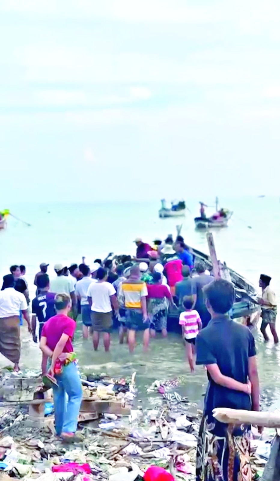 TAK BERNYAWA: Warga menggotong jenazah Liman yang meninggal saat melaut di Pantai Camplong, Sampang, Senin (29/12). (BPBD UNTUK JPRM)