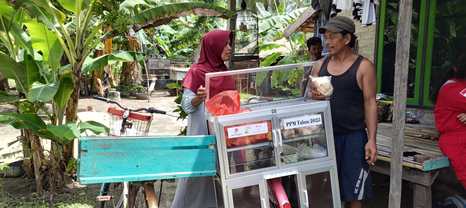 TERBANTU PPM KEI: Pasangan suami istri Salman dan Sualma menunjukkan dagangan dari sepeda rombong bantuan KEI di dekat sepeda lama di depan rumahnya di Desa/Pulau Pagerungan Kecil, Kamis (11/12).