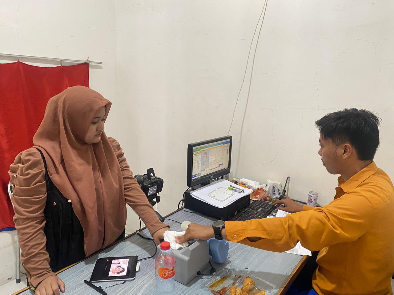 REKAM DATA: Pemohon dibantu petugas saat melakukan pemindaian sidik jari di Kantor Disdukcapil Sampang Senin (8/12/2025).