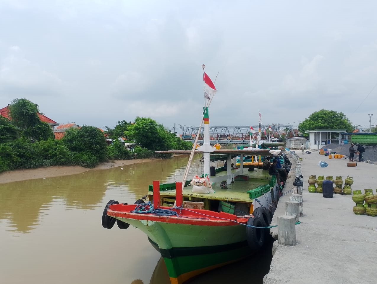 MENEPI: Warga berada di sekitar kapal yang belum berangkat ke Pulau Mandangin di Pelabuhan Tanglok, Sampang, Selasa (30/12/2025).