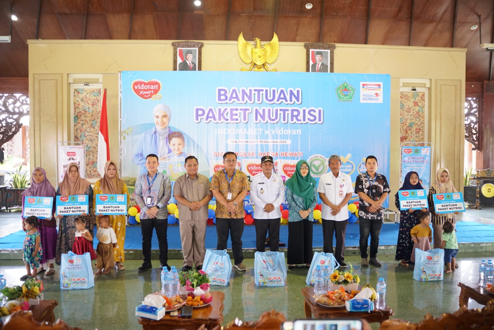 BERBAGI: PT Indomaret Cabang Gresik Williandi Sitepu (enam dari kiri) dan tim berfoto bersama Wabup Pamekasan Sukriyanto saat menyerahkan bantuan di Mandhapa Agung Ronggosukowati, Rabu, (10/12/25).