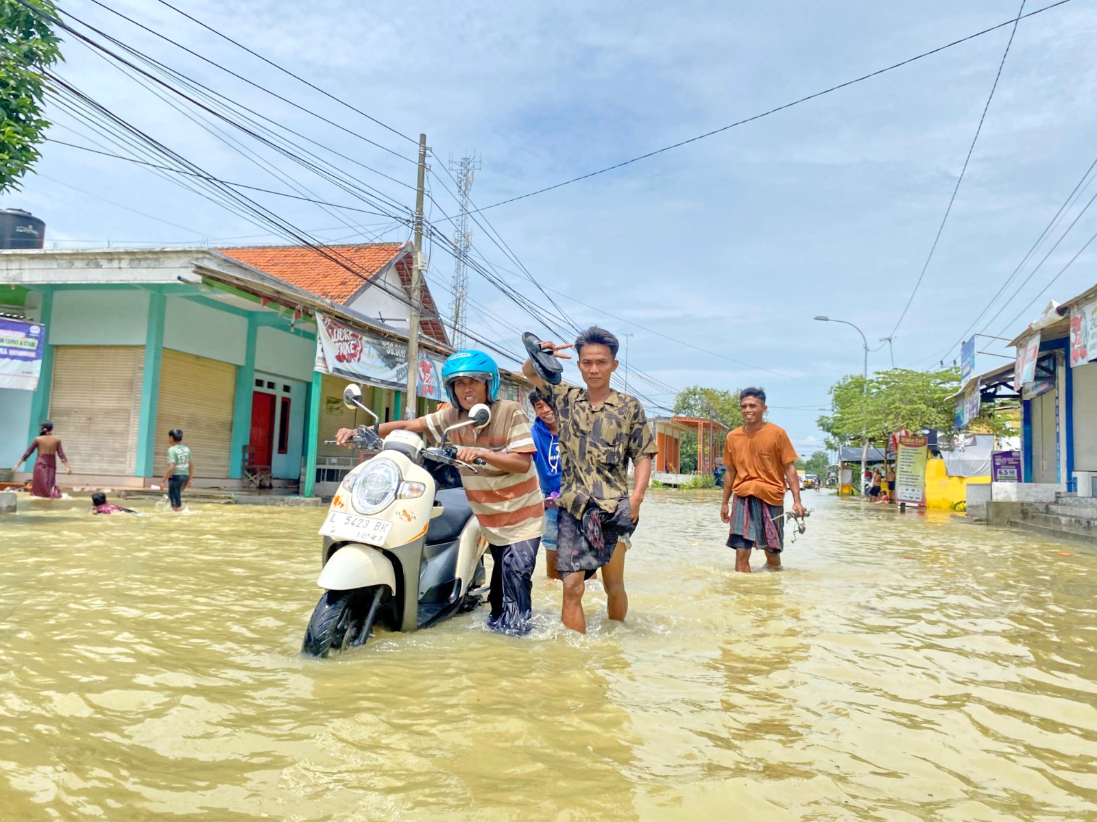 MENGGENANG: Warga tampak hati-hati melintas di Jalan Raya Panggung, Kecamatan Sampang, Minggu (4/1). (AYU LATIFAH/JPRM)