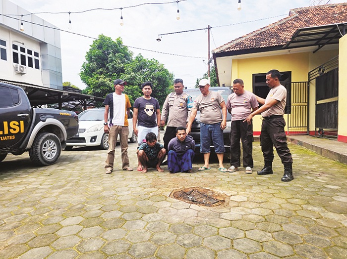 TAK BERKUTIK: Anggota Polsek Banyuates, Sampang, berpose bersama dua terduga pelaku yang berhasil diamankan, Selasa (6/1). (HUMAS POLRES UNTUK JPRM)