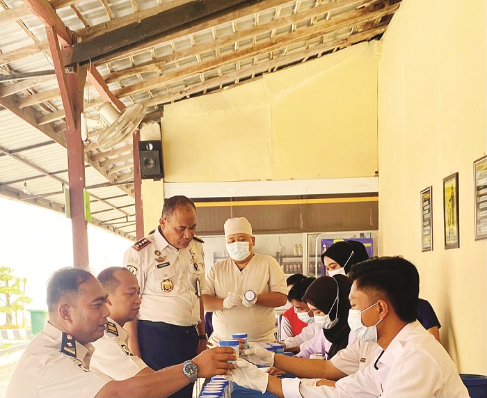 DIAWASI: Kepala Lapas Kelas II-A Pamekasan Syukron Hamdani memeriksa tes urine pegawai dan napi Rabu (7/1). (MOH. IQBAL AFGANI/JPRM)