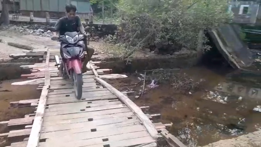 RAPUH: Masyarakat melintas di jembatan sementara di Desa Bringsang, Kecamatan Gili Genting, Sumenep.