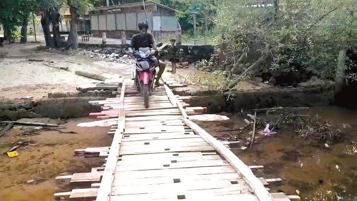 BUTUH PENANGANAN: Warga melintas di jembatan alternatif di Desa Bringsang, Kecamatan Gili Genting, Sumenep. (RIFAN UNTUK JPRM)