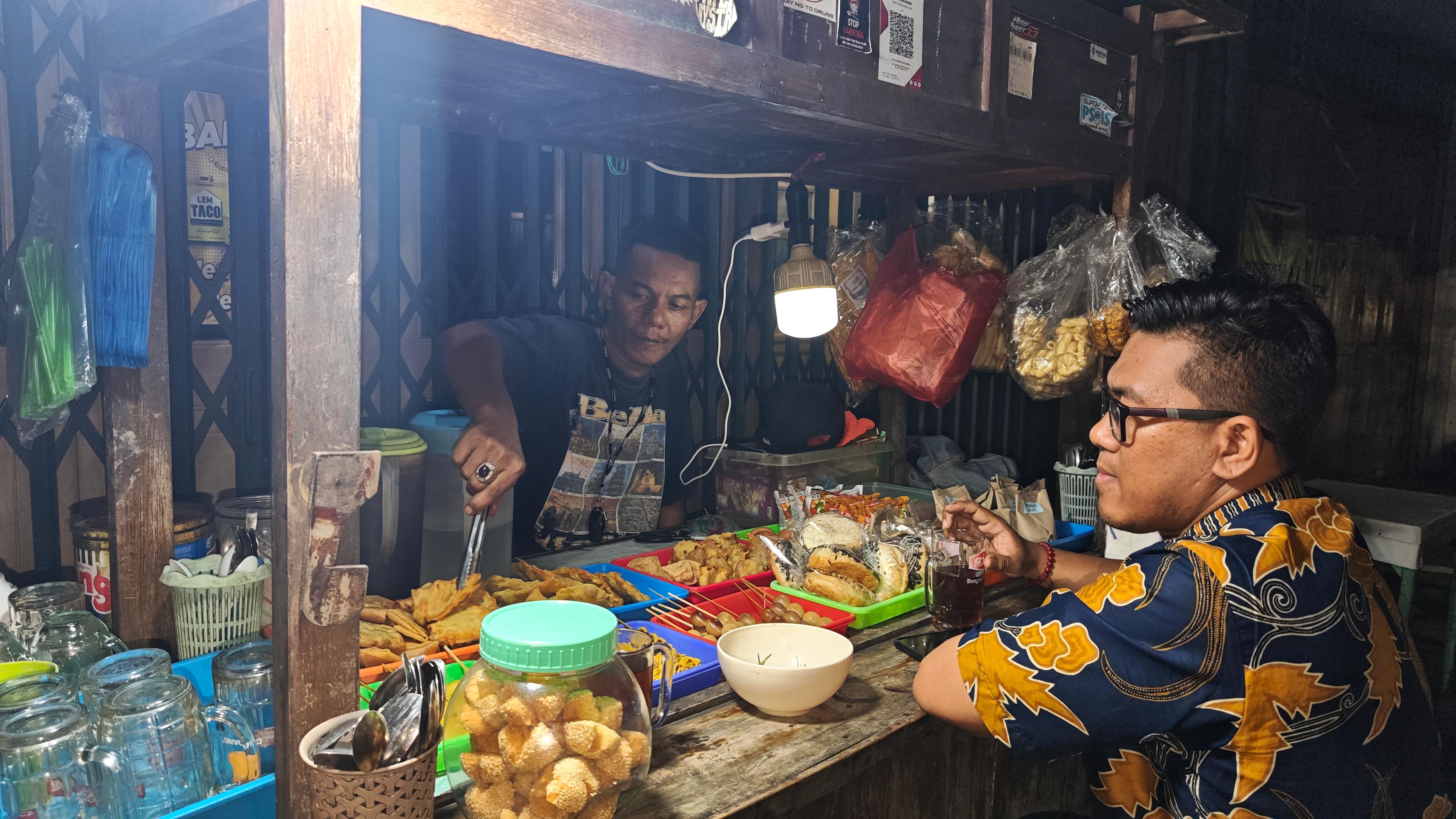 MERAKYAT: Warga Karang Kebon Utara, Semarang menikmati aneka camilan di angkringan  binaan KUR BRI.