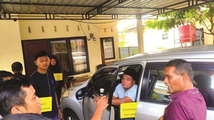 REKONSTRUKSI: Anggota Polres Sampang melakukan rekonstruksi perkara pembacokan di halaman Mapolres Sampang, Kamis (8/1). (MADJURI UNTUK JPRM)