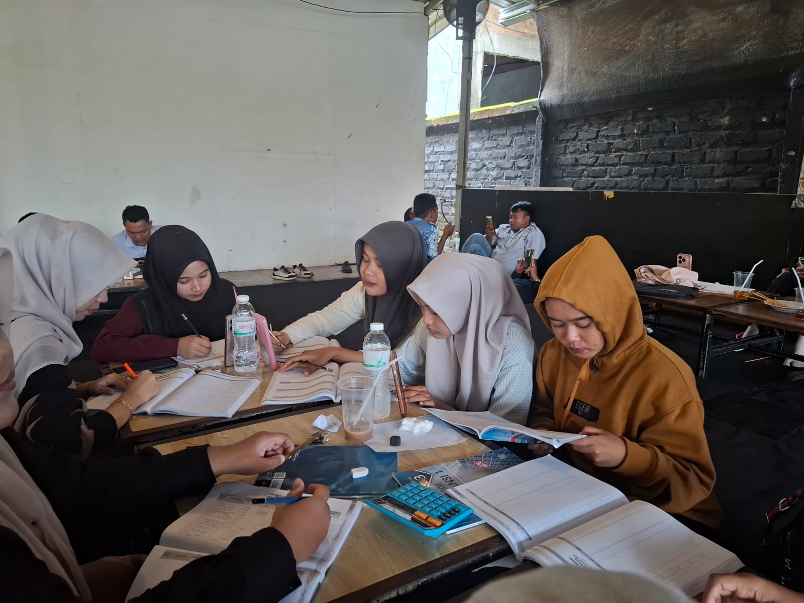 FOKUS: Sejumlah mahasiswa tengah mengerjakan tugas di salah satu warung kopi di Sumenep, Rabu (24/1).