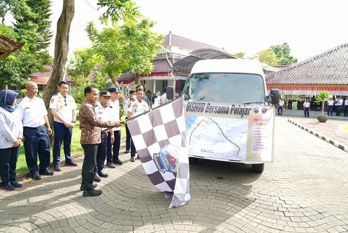 DI-LAUNCHING: Bupati Bangkalan Lukman Hakim (pegang bendera) memberangkatkan armada bus sekolah gratis di Pendopo Agung Kamis (15/1). (PROKOPIM UNTUK JPRM)