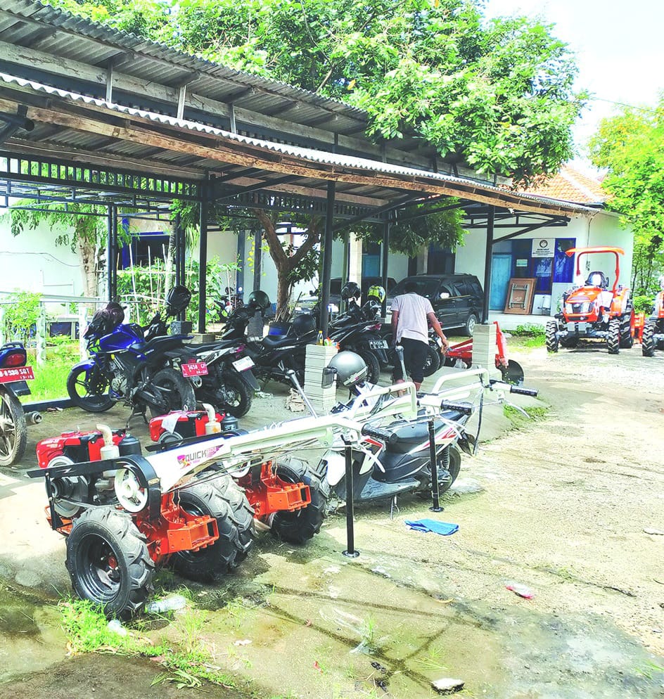 BELUM DISALURKAN: Warga berada di sekitar dua mesin hand tractor yang belum disalurkan di halaman belakang kantor Disperta KP Sampang Kamis (15/1). (UBAIDILLAHIR RAIE/JPRM)