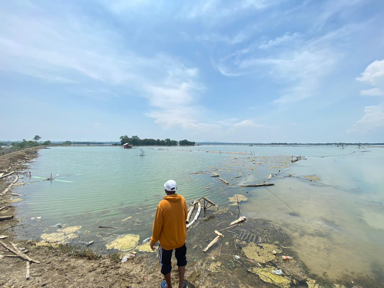 LAHAN: Seorang pelaku usaha tambak saat melihat lahan tambaknya, Senin (8/12/2025).