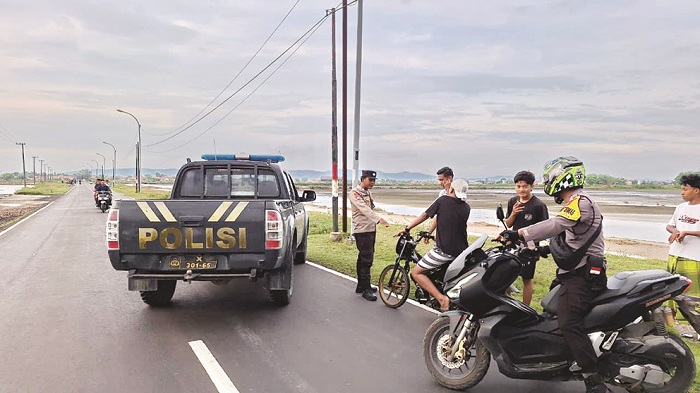 PATROLI: Petugas meemberhentikan sejumlah pemuda yang terlibat balap liar di jalan raya Desa Plasah, Kecamatan Pangarengan, Sampang, beberapa waktu lalu. (POLRES UNTUK JPRM)