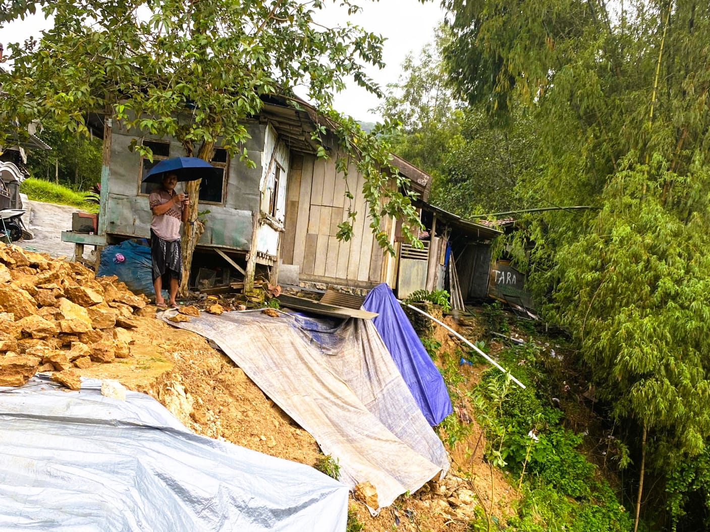 BERJARAK: Ahmad Salim warga Dusun Bagunung, Desa Ponjanan Timur, Kecamatan Batumarmar menunjukkan lokasi longsor di belakang rumahnya, Jumat (16/1).