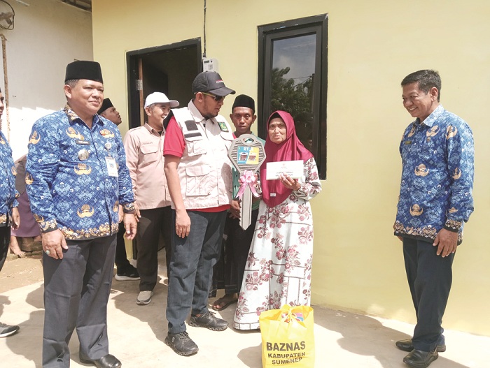 TEPAT SASARAN: Bupati Sumenep Achmad Fauzi Wongsojudo menyerahkan kunci rumah program RTLH kepada penerima di Desa Gelugur, Kecamatan Batuan, Senin (19/1). (PROKOPIM SUMENEP UNTUK JPRM)