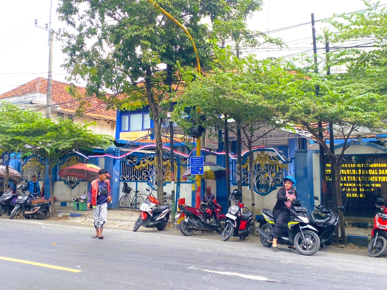 PENERTIBAN: Petugas Jukir saat membantu pengendara motor di depan Pasar Srimangunan, Minggu (18/1).